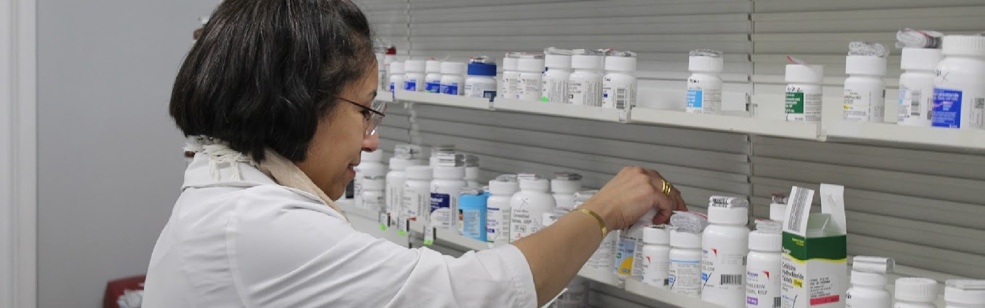 A pharmacist picking pharmaceutical products in a shelves